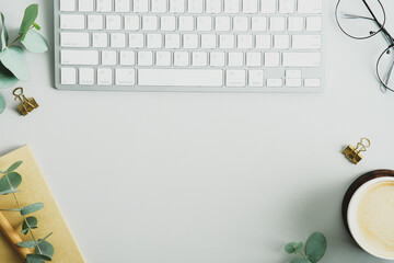 Canvas Print - Office desk table with keyboard, coffee cup, eucalyptus branches and office supplies. Elegant feminine workspace top view. Flat lay, overhead.