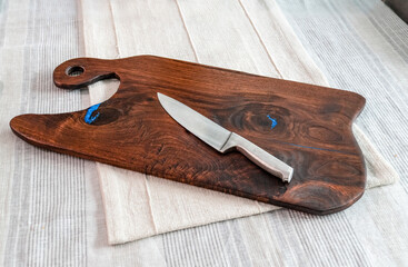 Wooden charcuterie board with cutting knife on a linen table cloth