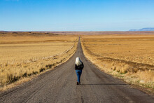 USA, Nevada, Winnemucca, Senior Woman Walking Down Desert Road