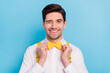 Photo of flirty funky guy dressed white shirt correcting yellow bowtie winking isolated blue color background