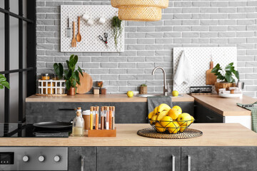 Basket with different fruits on table in kitchen interior