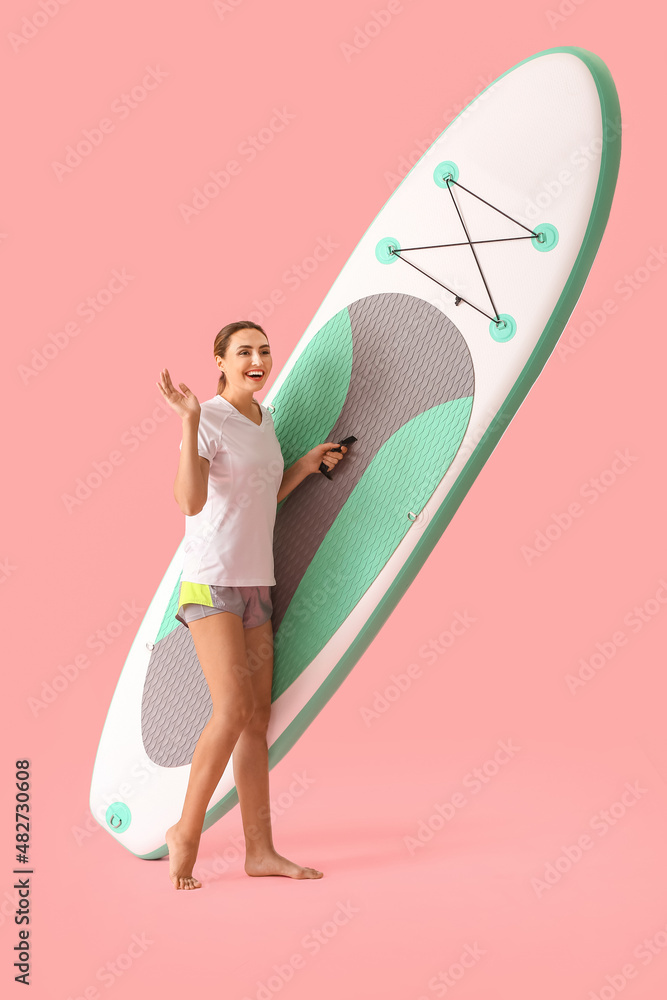 Young woman with board for sup surfing on color background