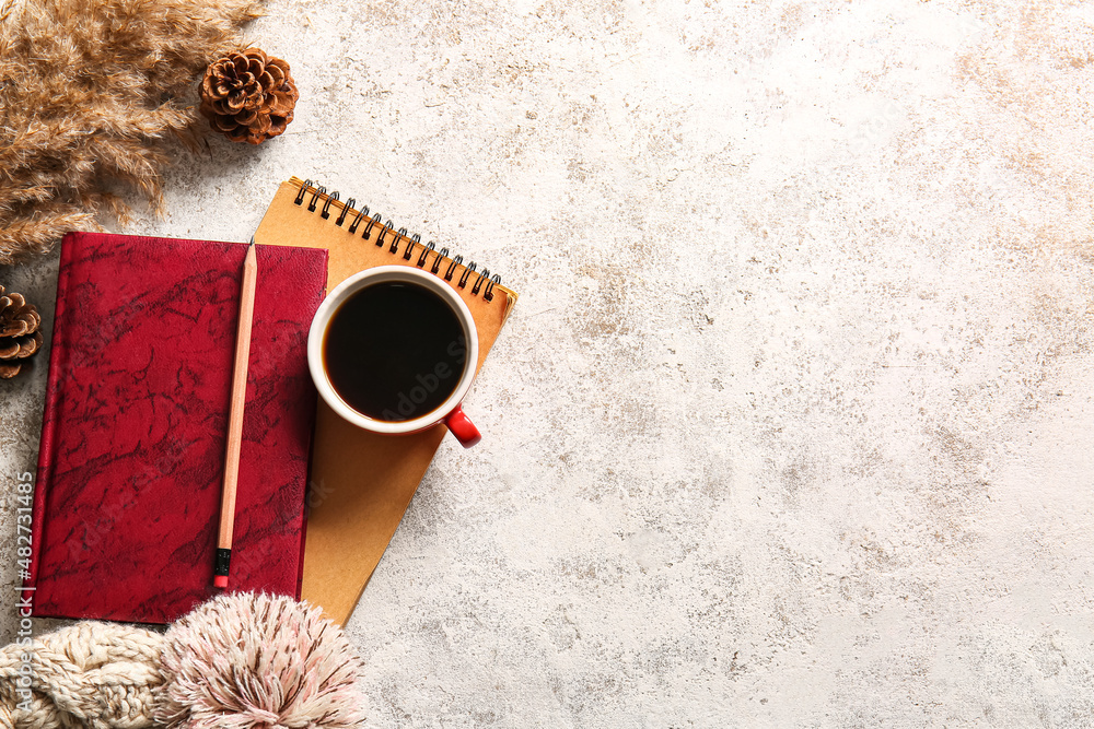 Book, cup of coffee and warm hat on light background