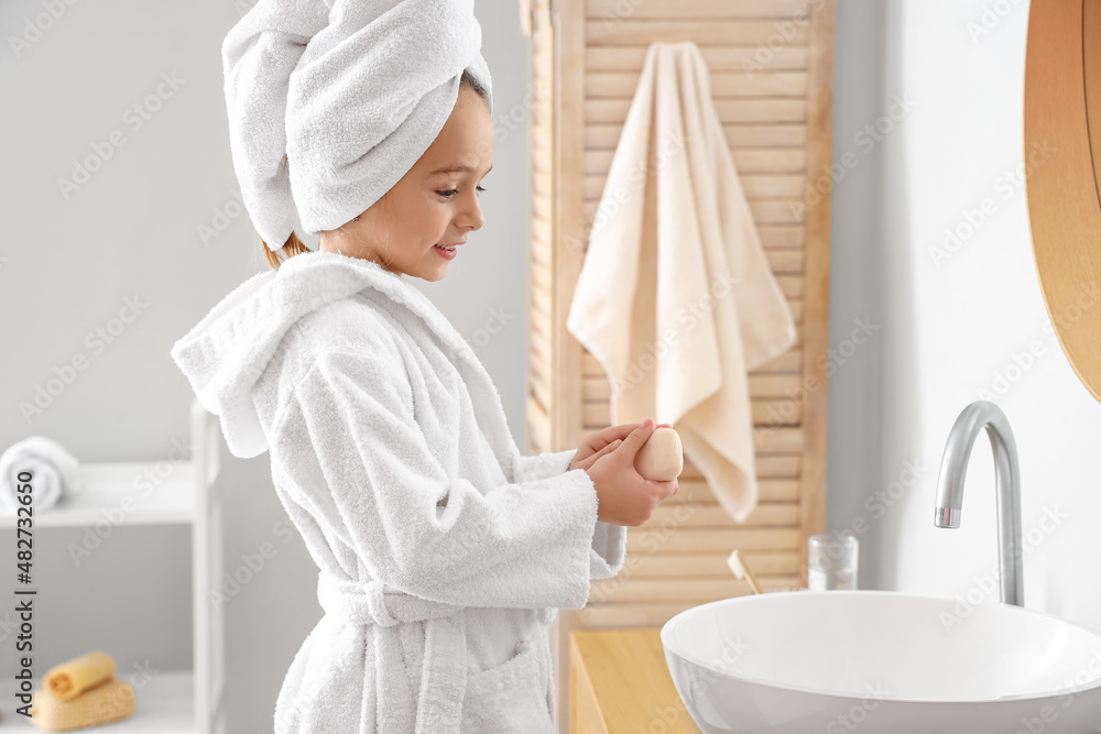 Cute little girl washing hands in bathroom