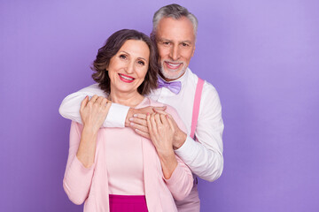 Poster - Portrait of two idyllic cheerful elderly partners hug trust care isolated on violet color background