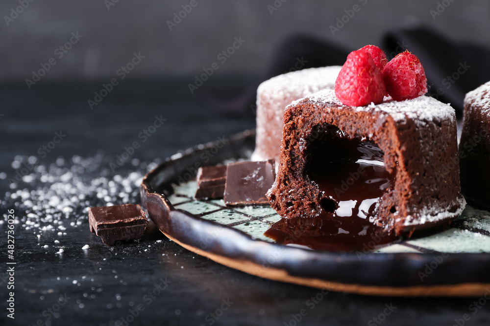 Plate with tasty lava cake fondant and raspberry on dark background, closeup