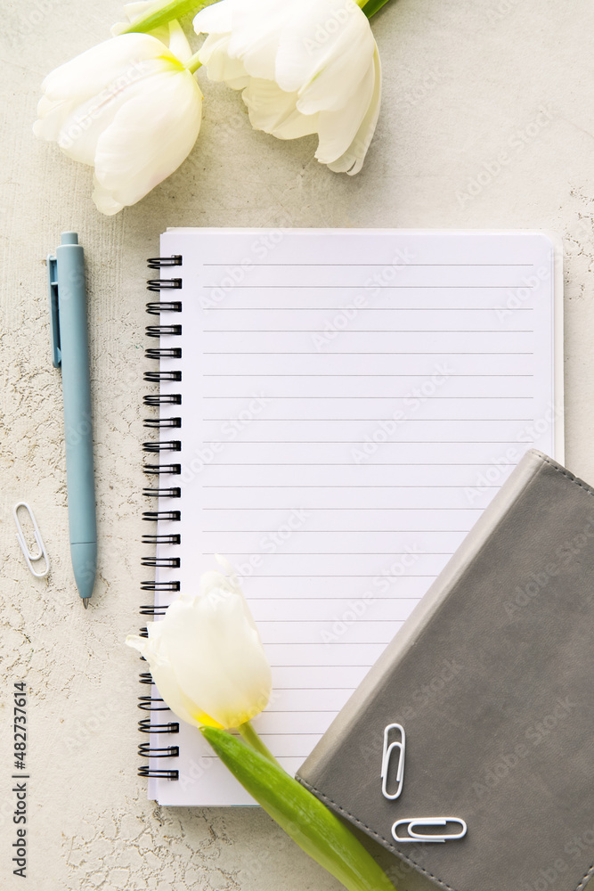 Composition with blank notebook and tulips on light background, closeup