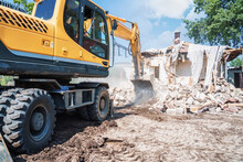 Yellow Excavator Or Bulldozer Destroys Building. Building Demolition.