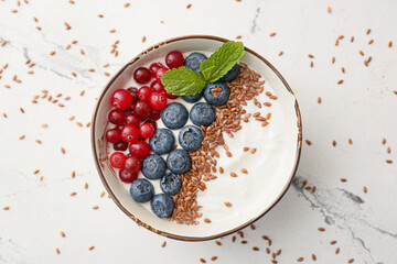 Bowl of sweet yogurt, flax seeds and berries on white background