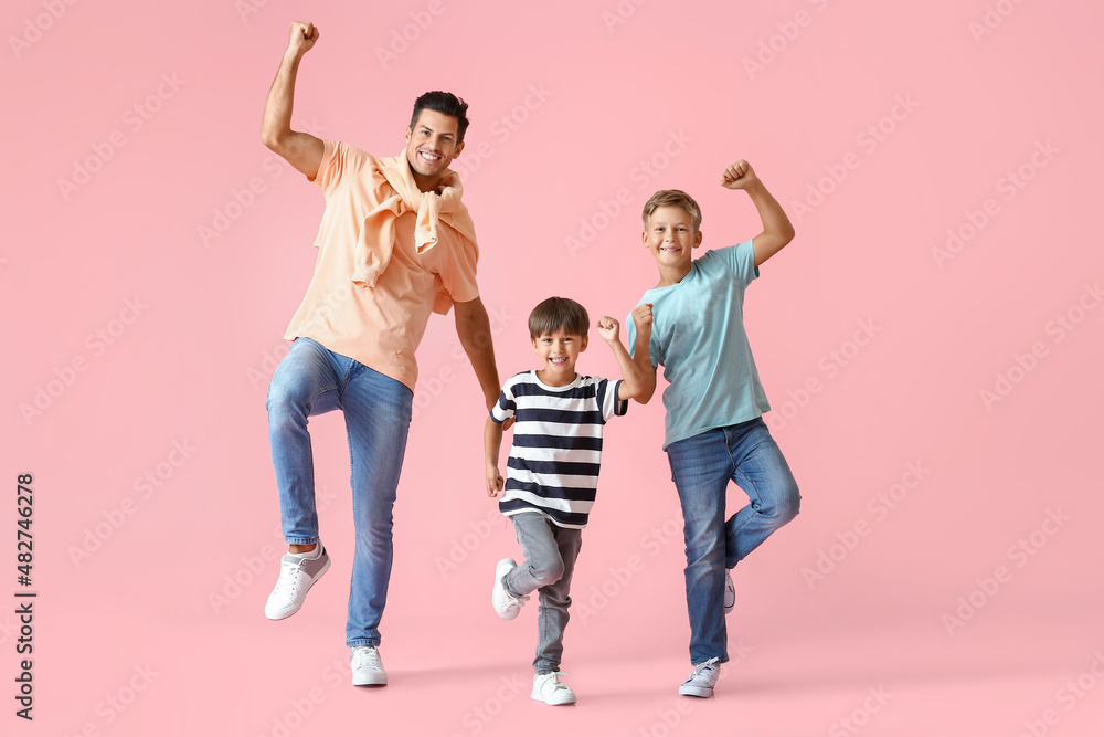 Happy dancing man and his sons on color background