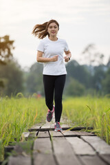 Wall Mural - woman running on wooden path in field