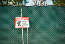 No Trespassing Or Loitering Sign On Fence