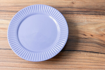 An empty gray plate on a wooden surface