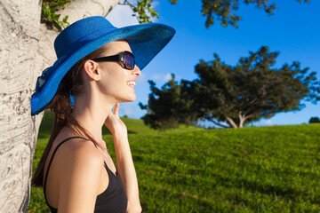 Wall Mural - portrait of a woman in a hat outdoors enjoying nature and sunshine 