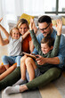 © NDABCREATIVITY - Device technology family online education concept. Happy family with digital devices at home.