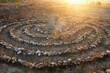 Spiral stone labyrinth in the rays of the sunset. Mystic stone seven-turn maze.