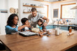 © Chanelle M/peopleimages.com - The whole family is getting involved. Cropped shot of a young couple baking at home with their two children.