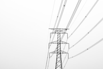 High voltage electricity transmission tower under the foggy sky in the evening with copy space