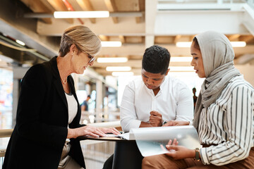 Canvas Print - Putting their heads together over some business reports