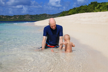 Wall Mural - Father with a baby playing at the beach, White Island, Grenada.