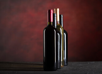 Wall Mural - Wine bottles collection on a dark red background with copy space