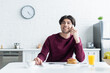 © LIGHTFIELD STUDIOS - happy man talking on mobile phone near delicious pancakes and beverages in kitchen.