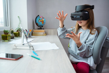 Wall Mural - schoolgirl is using virtual reality simulator headset for study. child is wearing virtual reality gl
