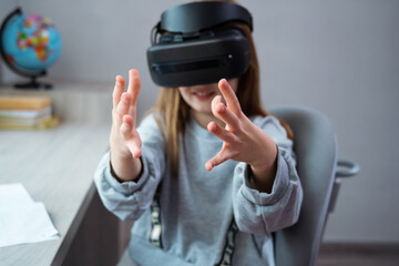 Wall Mural - schoolgirl is using virtual reality simulator headset for study. child is wearing virtual reality gl