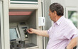 Senior man inserting credit card to ATM
