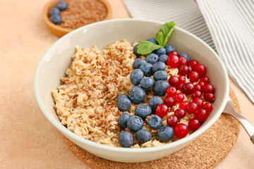 Bowl with tasty oatmeal and berries on grunge background