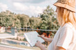 European woman in hat checking a city map in urban city park. Vacation trip, lifestyle holiday concept