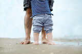 Fototapeta Fototapety z morzem do Twojej sypialni - Father and son walking by the ocean