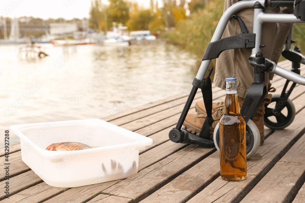 Man in wheelchair fishing on river