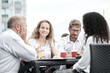 © Qwenergy - Smiling colleagues working together developing business strategy for their next project. Young casually dressed business people having discussion on sunny terrace. Modern job in comfortable conditions