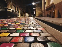 Surface Level Of Cobblestone Street In City At Night