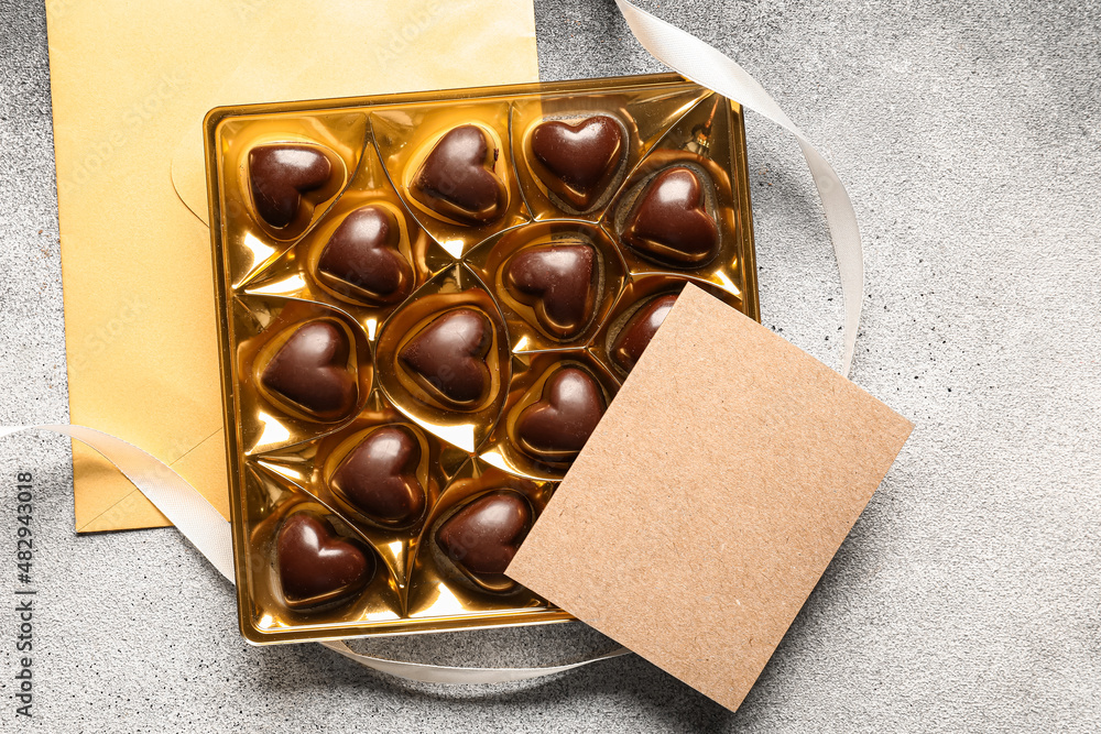 Box with tasty heart-shaped candies on light background