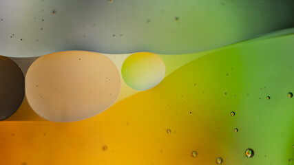 Canvas Print - A macro shot of floating oil and liquid green and orange bubbles