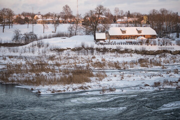 Wall Mural - House on island and river Venta in sunny, snowy winter morning, Kuldiga, Latvia