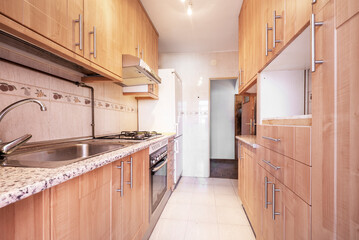 Kitchen with lots of light wood cabinets, pink granite countertops and cream tile in short term rental apartment