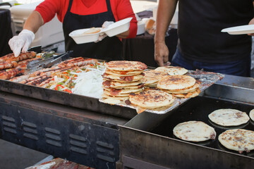 Wall Mural - A view of cooks preparing pupusas on the griddle.