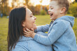 © Strelciuc - Side view portrait of a boy looking into his mother's eyes while playing with his hands touching his mother's face. Close up view. Holding hands. Smiling happy