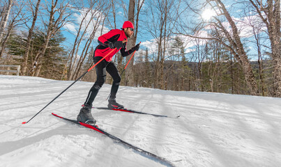 Cross Country Skate Skiing Style - Man on Nordic Ski in Forest in winter doing fun endurance winter sport activity in the snow on cross country ski in beautiful nature landscape