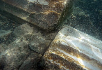 Wall Mural - Ruins of ancient column and construction blocks of antique city under water.