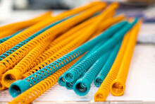 Yellow And Blue Metal Coil Spring Equipment Part Of Appliance Machine In Manufacturing Process Or Automotive Or Different Industrial Purposes On Table