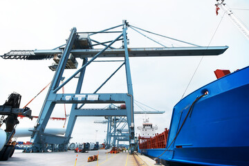 The harbor never sleeps. A massive cargo ship moored at the harbor while being loaded with containers.