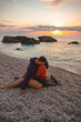 couple lovers at the beach enjoying time together and sunset above the sea