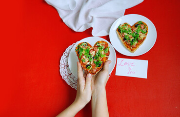 Heart shaped Pizza on Red background. St Valentin's Day celebration. Love background. Romantic dish. 