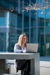 © Miquel - Woman with laptop outdoors in an office space, with copy space