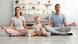 © Prostock-studio - Happy Family Of Three With Little Infant Baby Meditating Together At Home