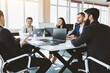 © xartproduction - Group of young business people working and communicating while sitting at the office desk together with colleagues sitting. business meeting